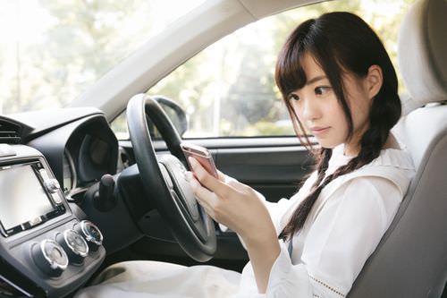 車中でスマホ見つめる