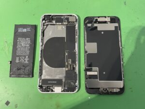 iPhoneSE(第2世代)を分解し、内部に水濡れ反応が無いか確認しながら古いバッテリーを慎重に取り外している様子
