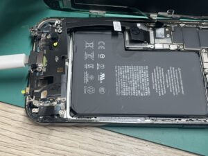Phone12ProMAXに新しいドックコネクターパーツを付け、正常に電流が流れているか通電テストを行っている様子