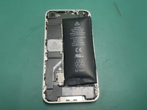 iPhone4の背面パネルを取り外し、膨らんだバッテリーを慎重に取り外して新しいバッテリーを取り付けている様子