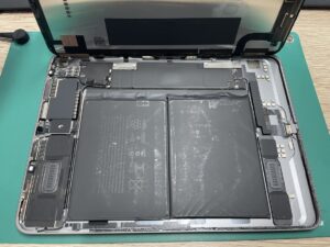 膨張したバッテリーを慎重に取り外し新しいバッテリーを仮付けしているiPadAir5