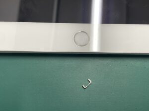 精密ツールを使用して充電口から異物を外から慎重に除去しているiPad7