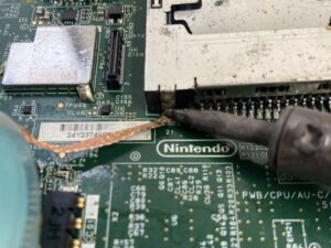 はんだ吸い取り線とはんだごてで古いハンダを除去する様子。