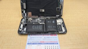iPhone Xの筐体内部。バッテリーの膨張によって空いた隙間からほこりが入ってしまっている。