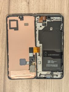 フロントパネルを開いて内部構造が見える状態のGoogle Pixel 8の分解風景