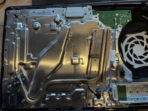 PS5のカバーを取り外した内部の様子。巨大な銀色のヒートシンクと冷却ファンが見える。