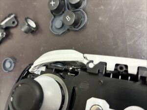 落下により位置ずれを起こしているLボタン内部の拡大写真