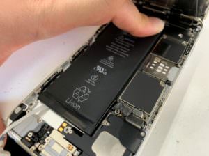 バイブレーションを外してバッテリーシールを取っているiPhone6