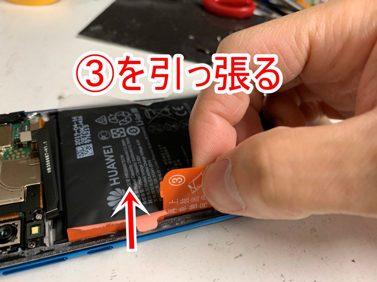 バッテリー固定シールを引っ張っているHUAWEI P30 lite