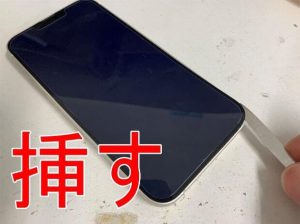画面と本体フレームの間にヘラを挿しているiPhone13