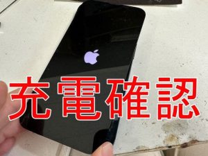 新品の充電口パーツへと交換して充電確認を行っているiPhone13