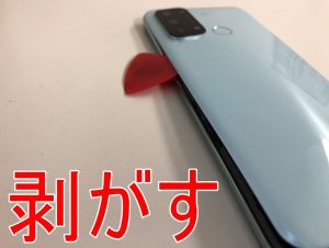 背面パネルの粘着テープを剥がして分解しているバッテリー交換前のOPPO Reno5 A