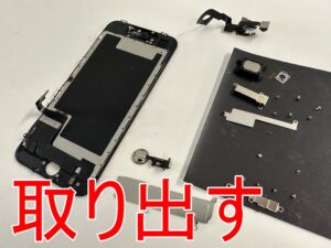 壊れた画面パーツからスモールパーツを取り出したiPhoneSE3