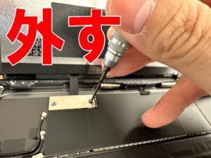画面パーツコネクタを固定した銀板のプラスネジを外しているフロントパネル交換修理中のiPad Air 第5世代