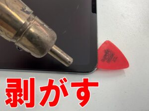 画面と本体フレームとの粘着を剥がしている電源ボタン修理中のiPad Pro 11インチ 第3世代