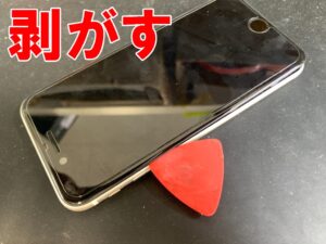 液晶画面を本体フレームから剥がしているバックカメラ交換修理中のiPhoneSE(第3世代)