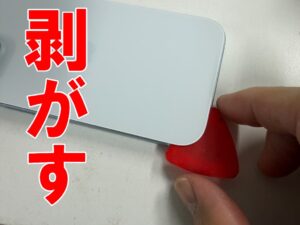 背面パネルの粘着を剥がしている電池交換修理中のiPhone15