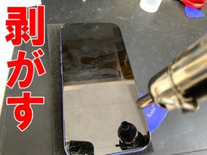 本体フレームからフロントパネルを剥がしているiPhone16