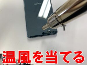 背面パネルに温風を当てている電池交換修理中のXperia5Ⅲ