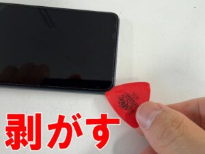 画面と本体フレームとの粘着を剥がしている充電口交換修理中のAQUOS sense8