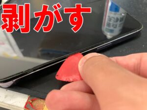 画面パーツを本体フレームから剥がしている水没復旧作業中のiPhone 14 Pro