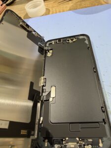iPhone 17eの割れた画面を取り外して内部を確認している状態