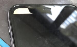 水没した iPhone の画面が左上だけわずかに映り、残り全体が黒く表示されていない状態