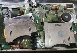 分解したNew3DSと交換前のゲームカードトレイパーツ