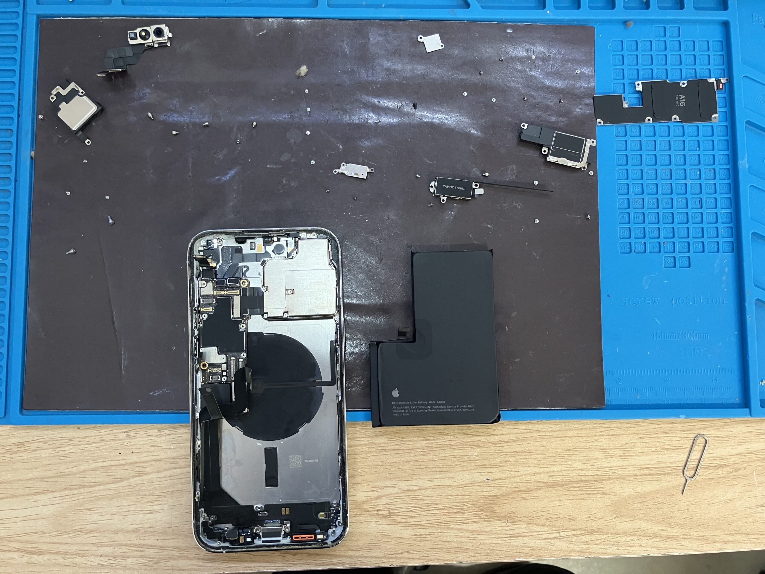 iPhone14 Pro Maxのドックコネクター交換で内部パーツと多数のネジを取り外した状態
