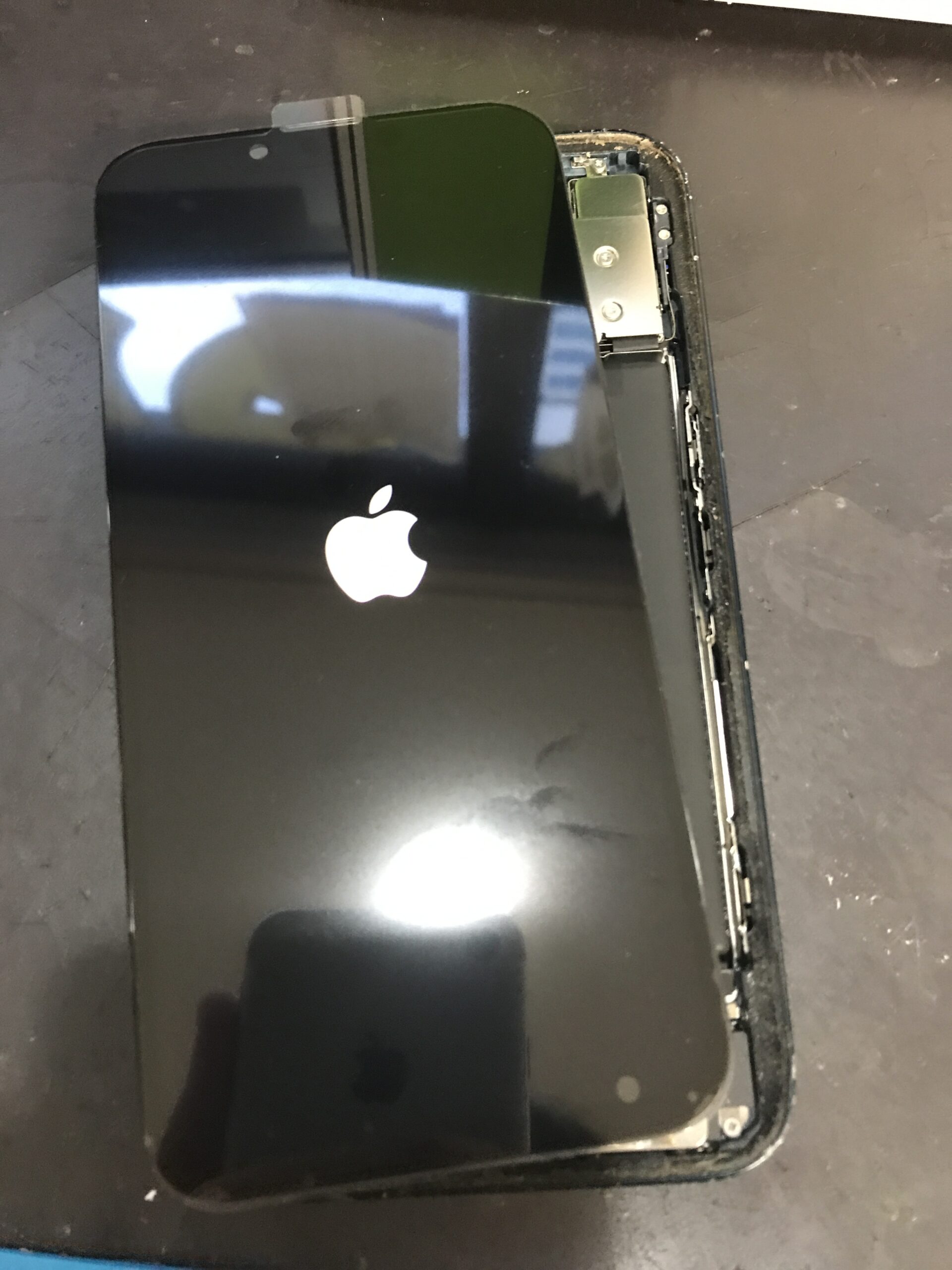 iPhone 13に新しい画面を仮付けして正常な表示を確認している修理中の状態