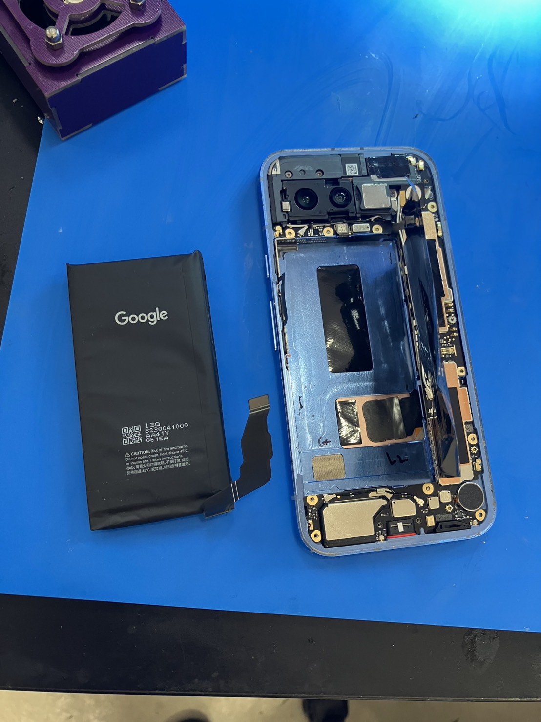 Pixel 8aから取り外した膨張バッテリーと修理中の本体
