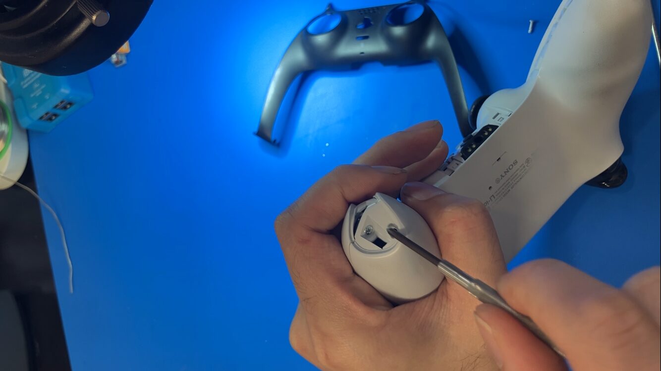 DualSenseの下部カバー内側にある固定ネジを取り外す作業