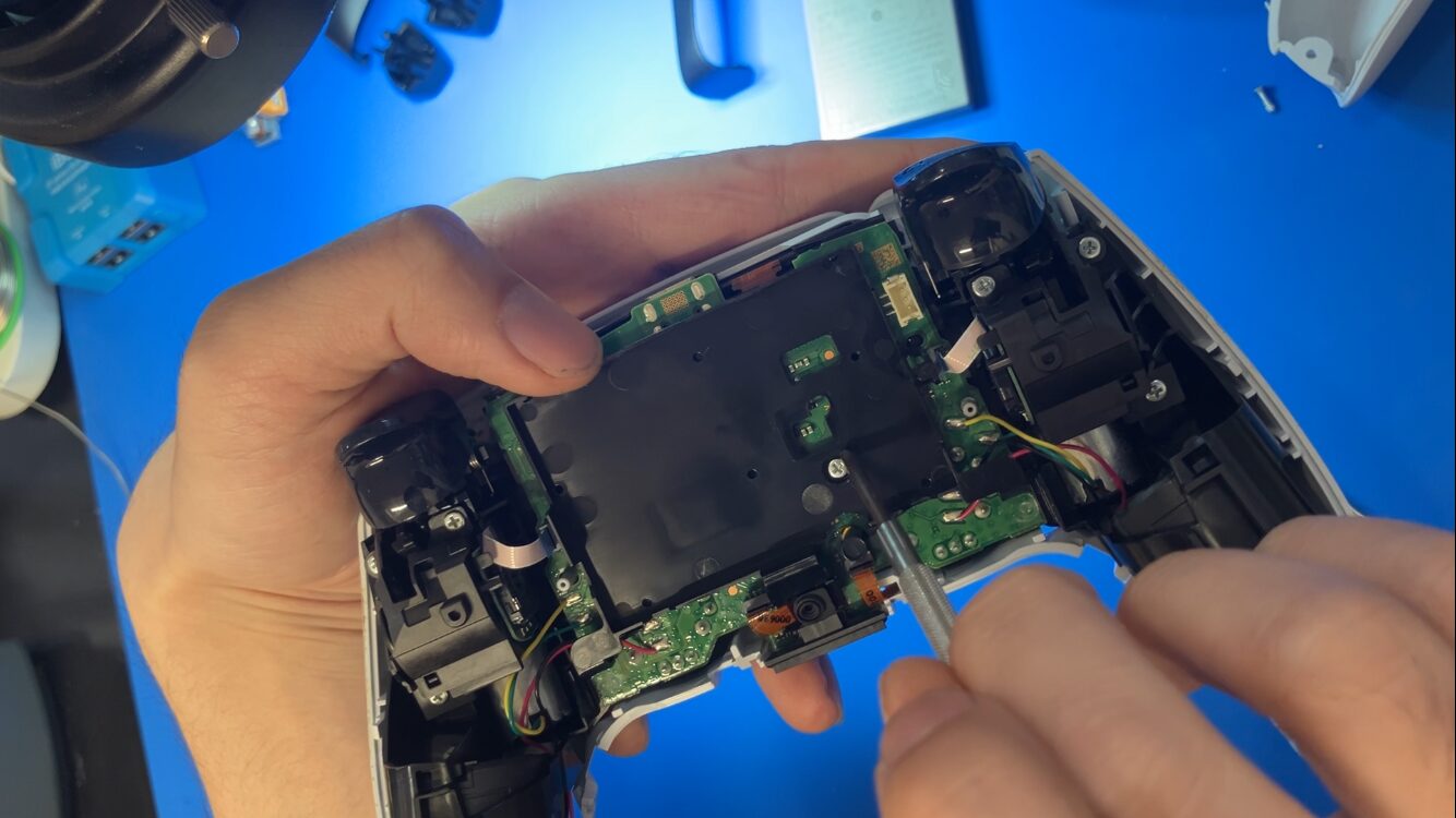 DualSenseのバッテリー固定カバーのネジを取り外す作業