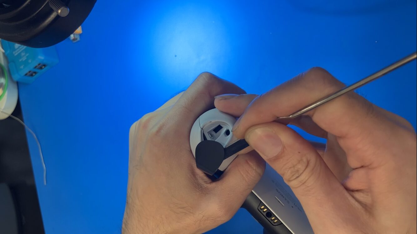 DualSenseの下部黒いカバーをヘラで取り外す工程