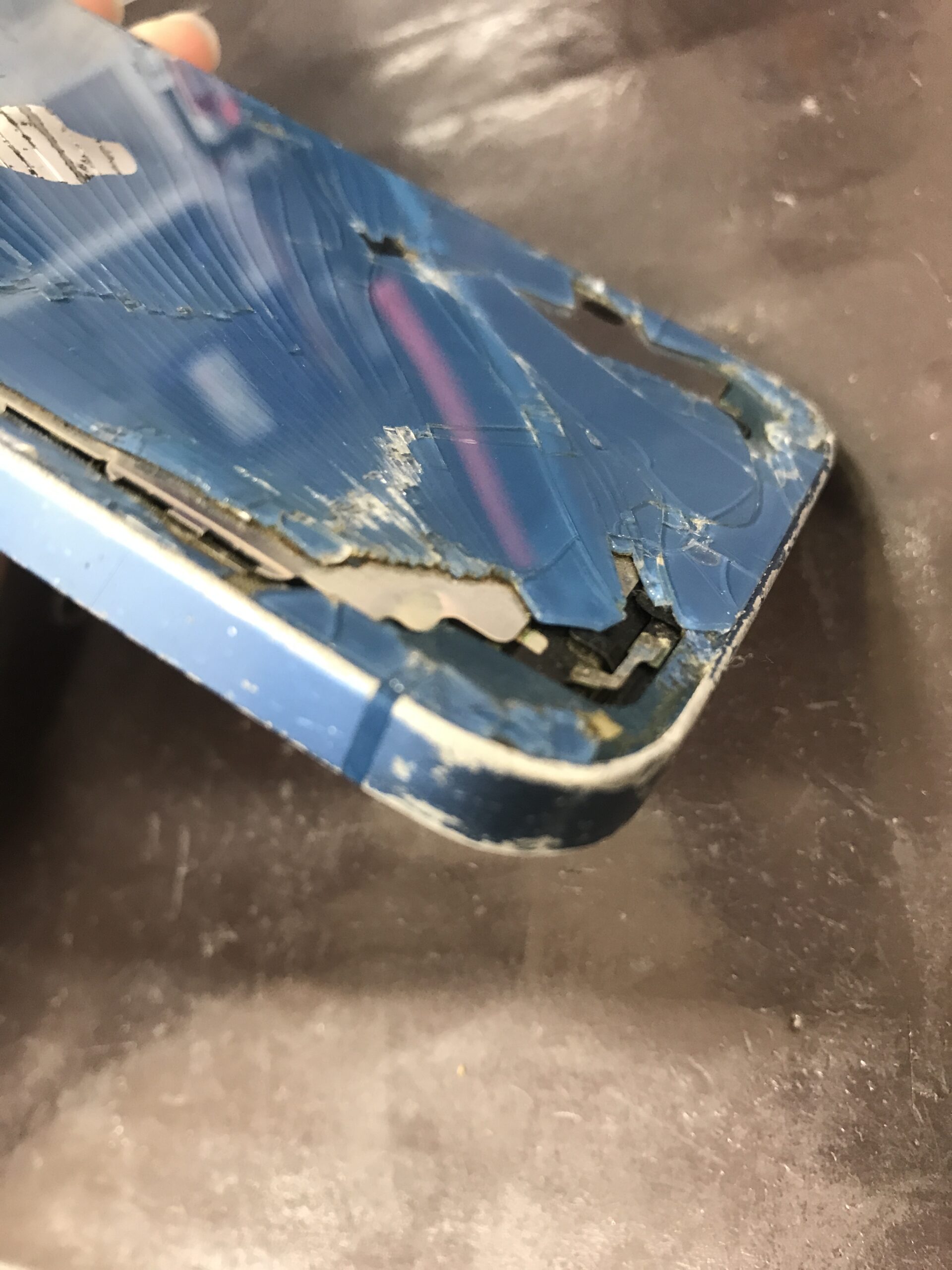 画面と背面が破損したiPhone 13の本体側面の状態